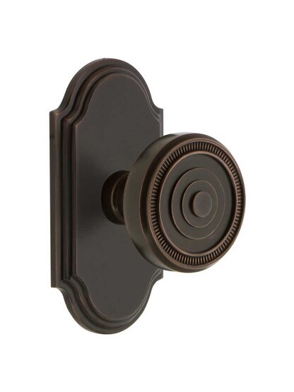 Grandeur Arc Rosette Door Set with Soleil Knobs in Timeless Bronze.